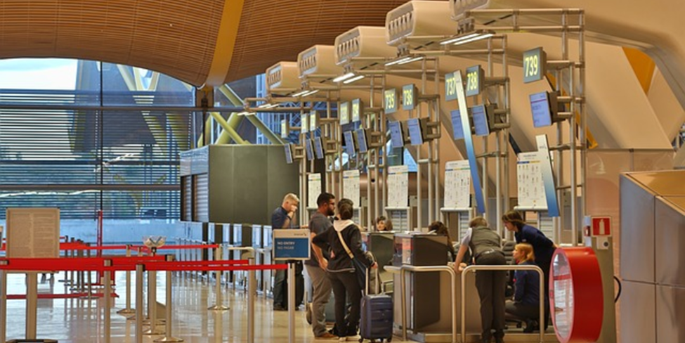 "Passengers checking in at an airport counter."