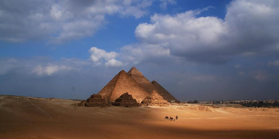 "Tourists exploring the Pyramids of Giza under a clear blue sky – Safe travel in Egypt 2025."