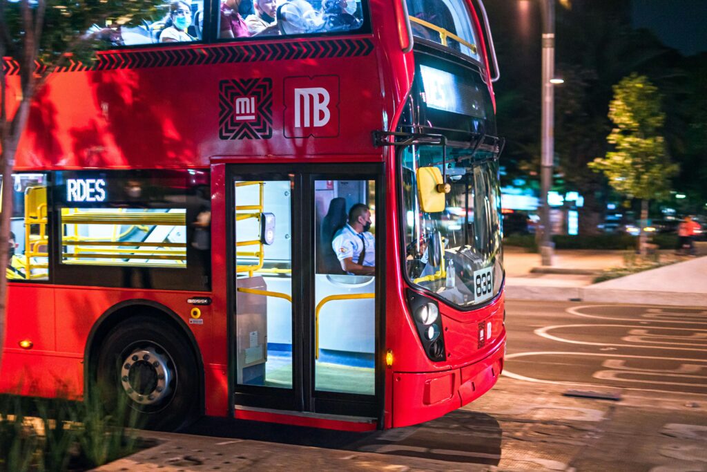 Is mexico a city safe?A vibrant red city bus transporting passengers at night in Ciudad de México.