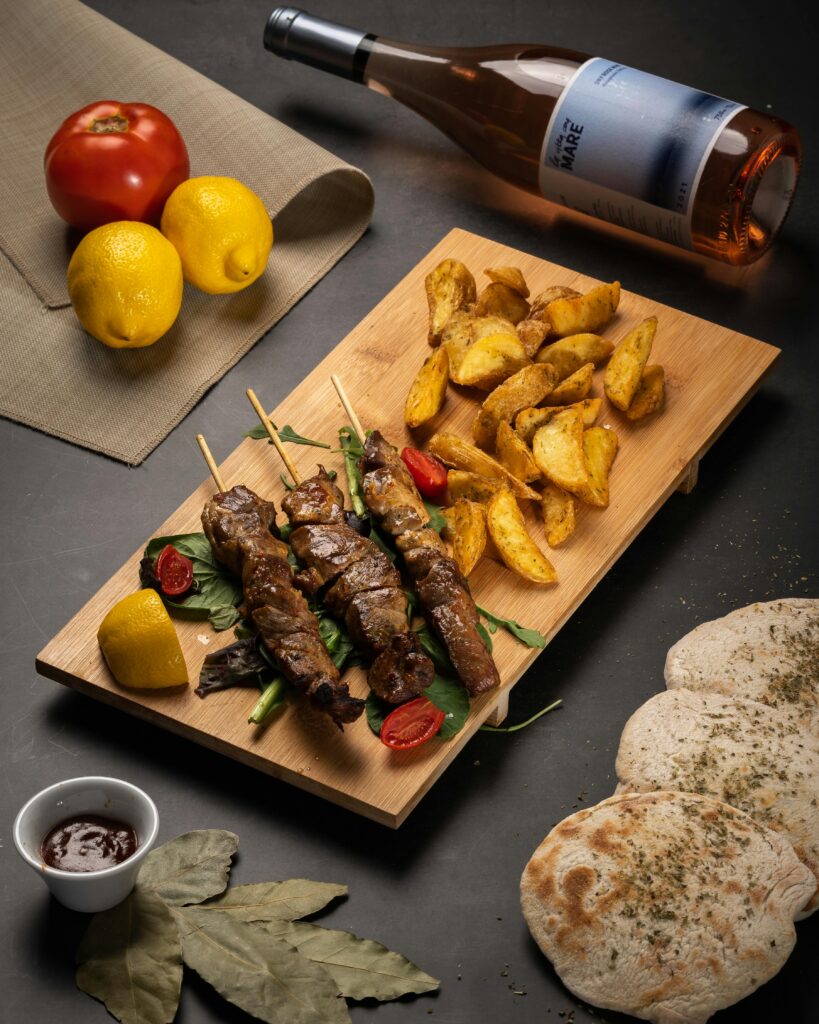 Delicious Greek souvlaki skewers with roasted potatoes and wine. Perfect for an authentic Greek dining experience.