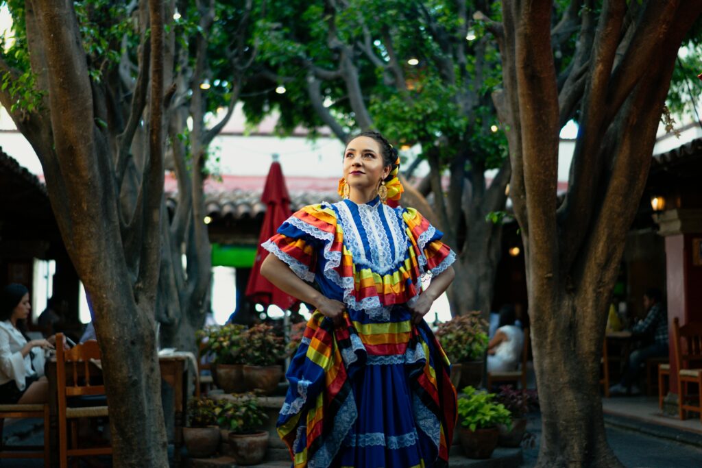 Is mexico a city safe? A smiling woman in traditional Mexican dress celebrates culture in a vibrant outdoor setting.