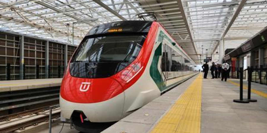 Modern commuter train at a sleek, glass-roofed station in Mexico, showcasing efficient public transportation.