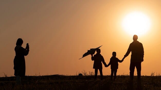 A silhouette of a family holding hands during sunset in an open field, with one person holding a toy airplane, symbolizing togetherness and a prayer for safe travel during a beautiful and serene moment.